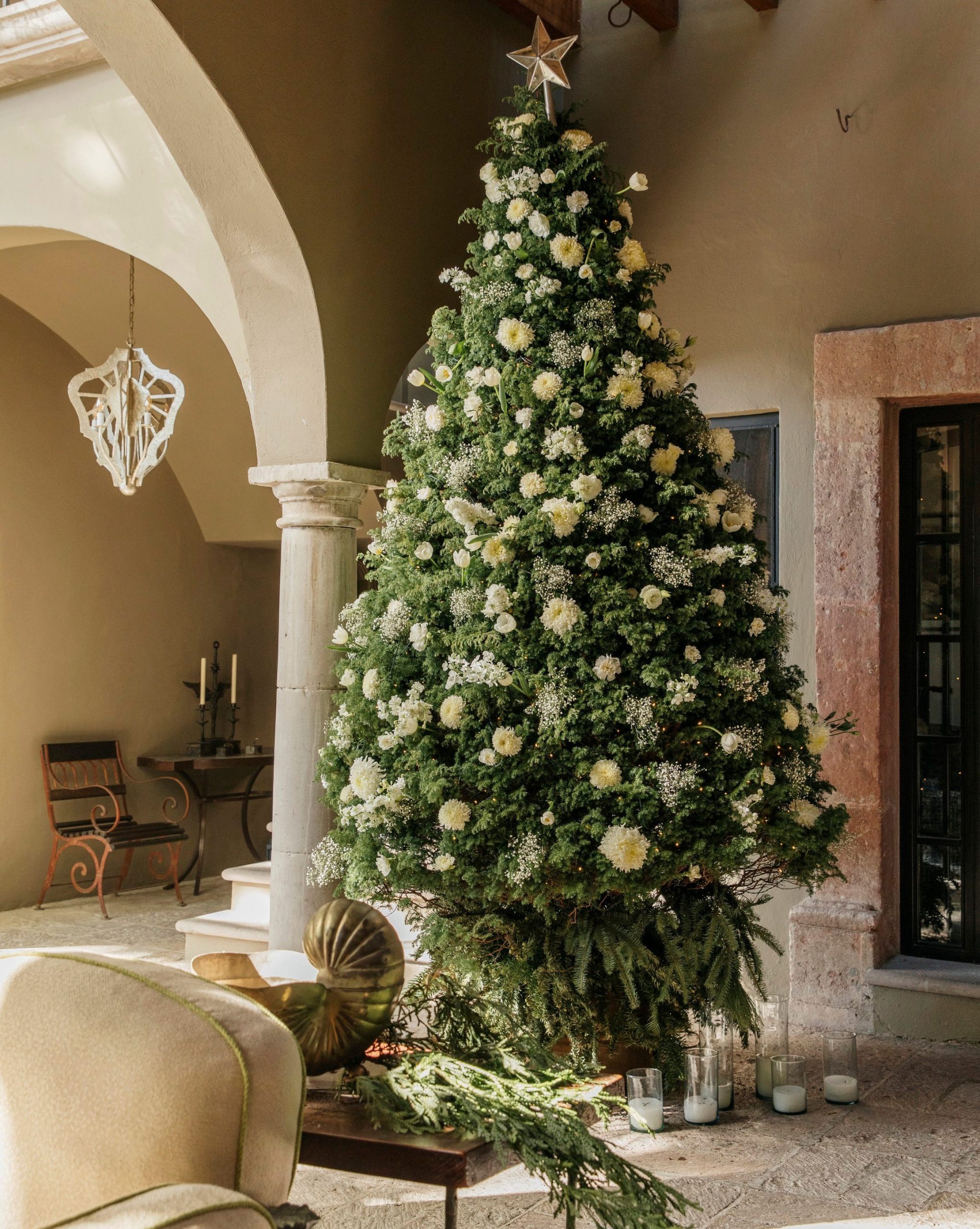 Outdoor Christmas Tree with Natural White Flowers on a Patio Outdoor Christmas Tree with Natural White Flowers on a Patio — Christmas Decor