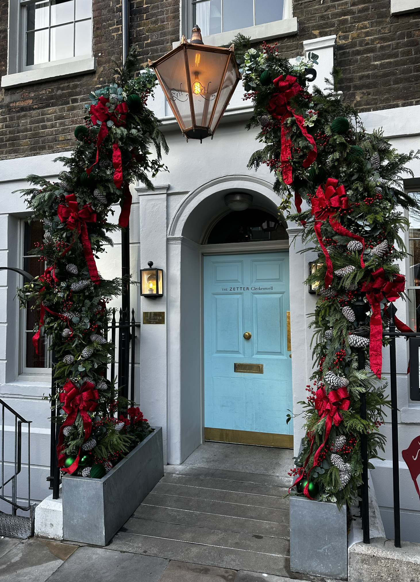 Dramatic Evergreen Archway with Red Bows for a Festive Entrance Dramatic Evergreen Archway with Red Bows for a Festive Entrance — Christmas Front Door Decor