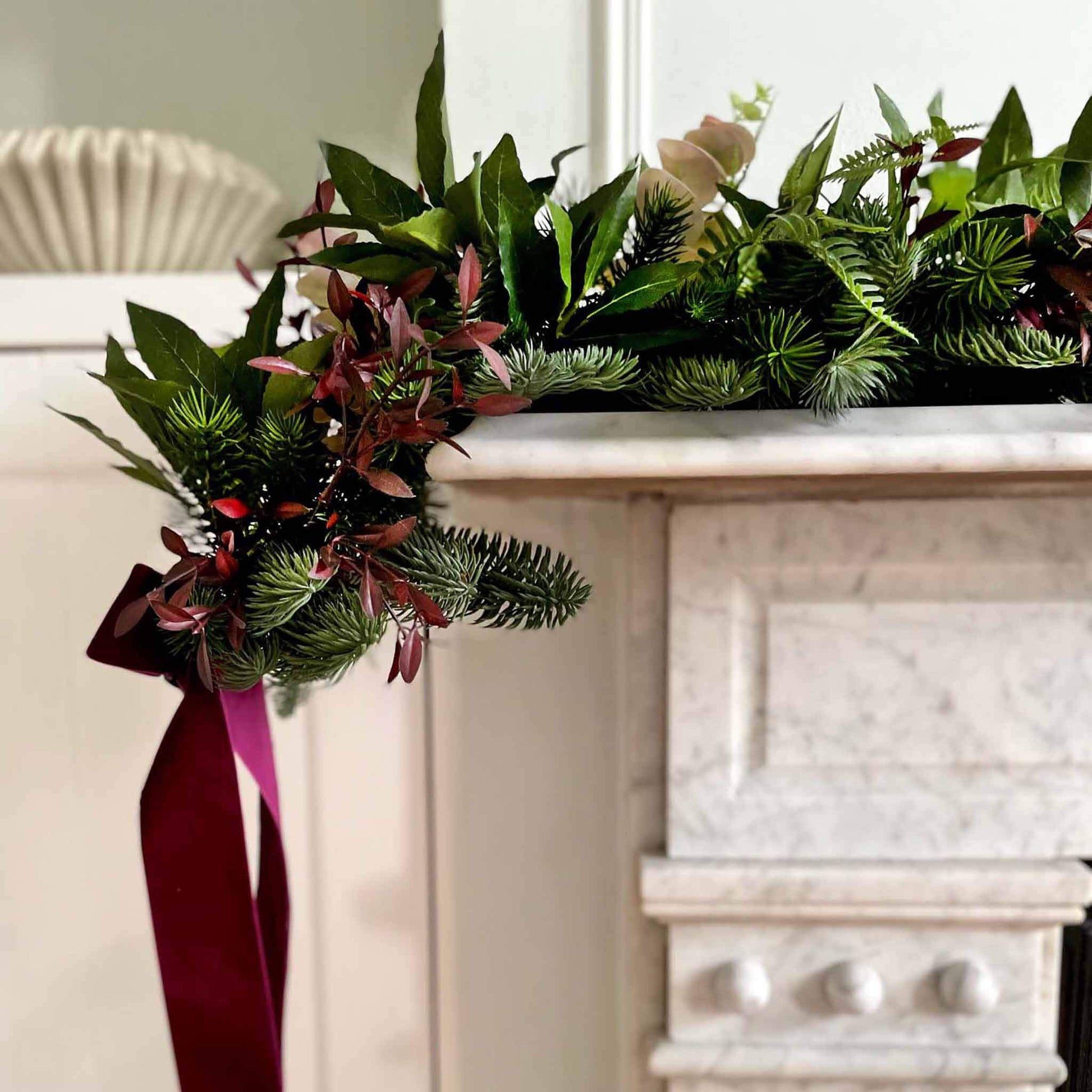 Mantelpiece Christmas Garland with Burgundy Velvet Ribbon on Marble Mantel Mantelpiece Christmas Garland with Burgundy Velvet Ribbon on Marble Mantel — Burgundy Christmas Decor