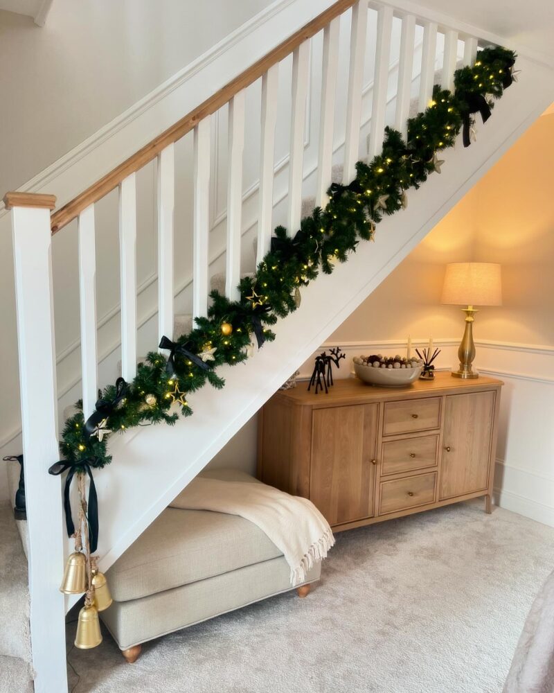 Modern Staircase with Black Ribbon, Gold Stars, and Sideboard Display Modern Staircase with Black Ribbon, Gold Stars, and Sideboard Display — Christmas Staircase Decor