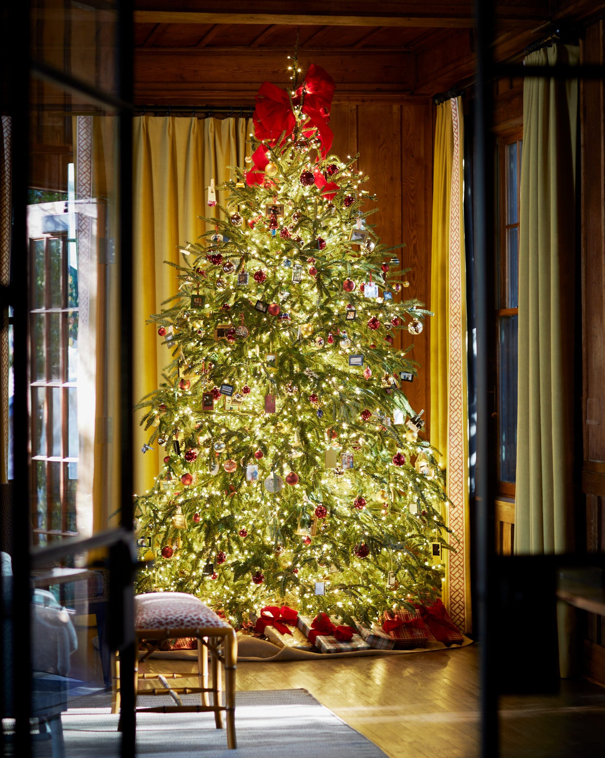Modern Living Room with Wood Paneling and Large Christmas Tree with Red Bow — Modern Christmas Decor
