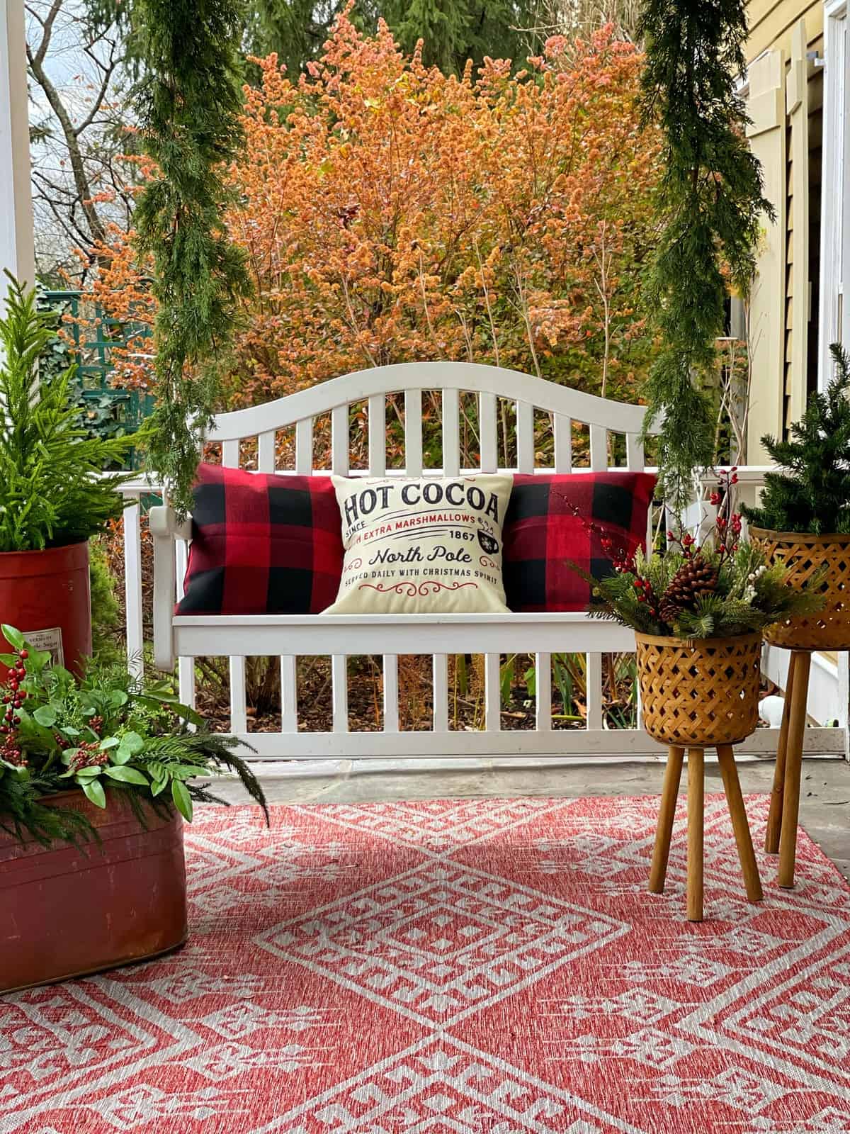 Cozy Farmhouse Porch Swing with Plaid Pillows and 'Hot Cocoa' Pillow — Farmhouse Christmas Porch