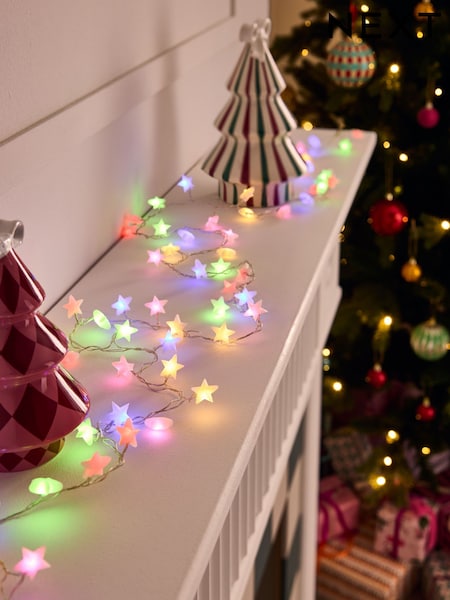 Multi-Colored Star Lights Adorn a White Mantelpiece — Christmas Lights Indoor