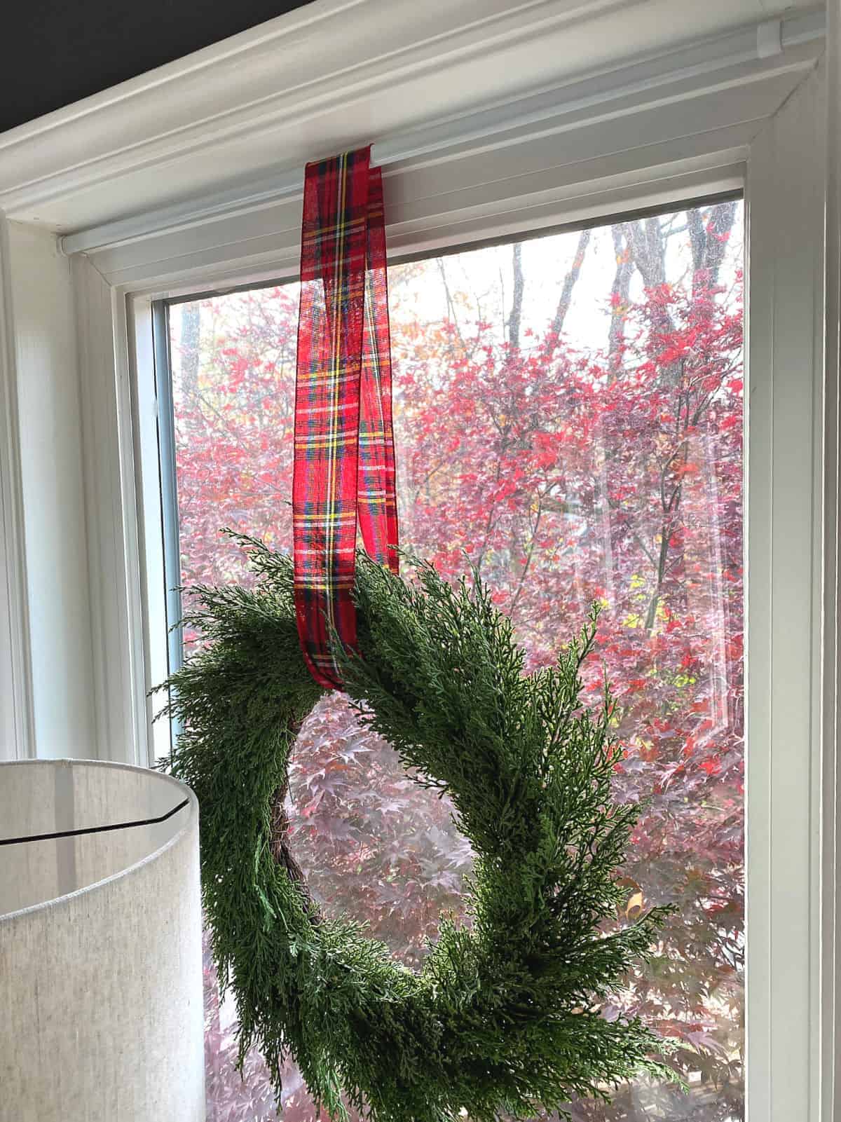 Cedar Wreath with Plaid Ribbon on an Indoor Window — Christmas Window Wreaths