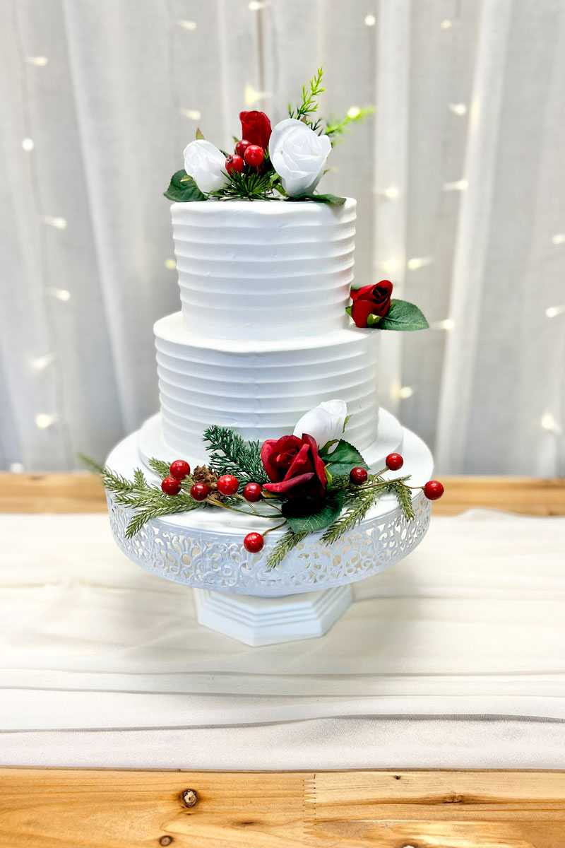 Festive Two-Tier White Wedding Cake with Red Rose Adornments Festive Two-Tier White Wedding Cake with Red Rose Adornments — Christmas Wedding Decor