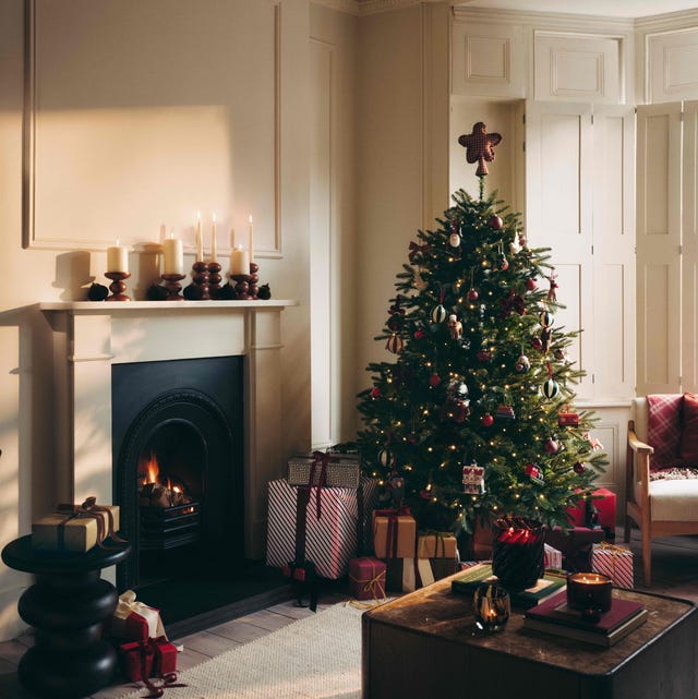 Classic Living Room with Crackling Fireplace and Piled Gifts Classic Living Room with Crackling Fireplace and Piled Gifts — Christmas Tree Trends 2026