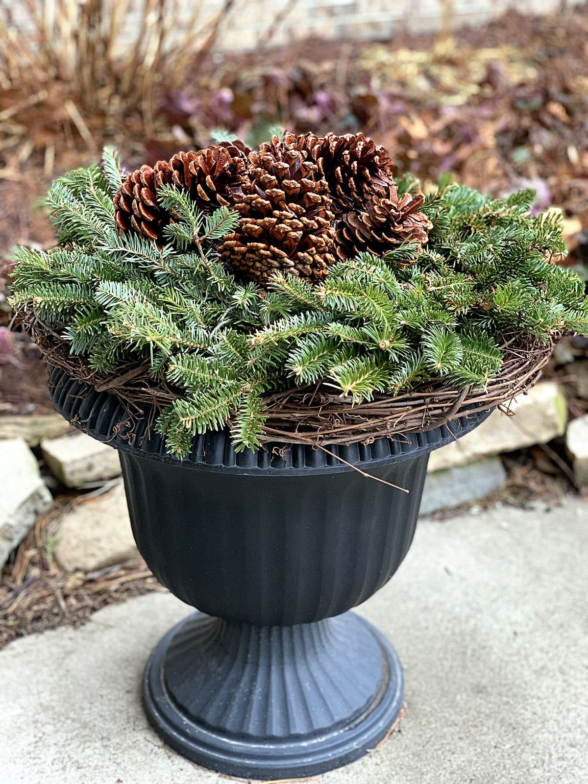 Rustic Urn Planter with Grapevine and Large Pinecones Rustic Urn Planter with Grapevine and Large Pinecones — Christmas Porch Planters