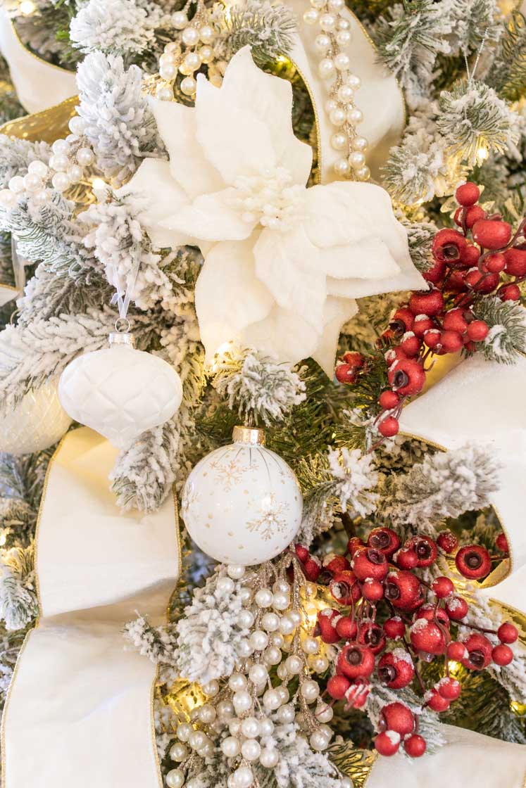 Close-up of White Christmas Tree with Poinsettias and Red Berries Close-up of White Christmas Tree with Poinsettias and Red Berries — White Christmas Tree Decor