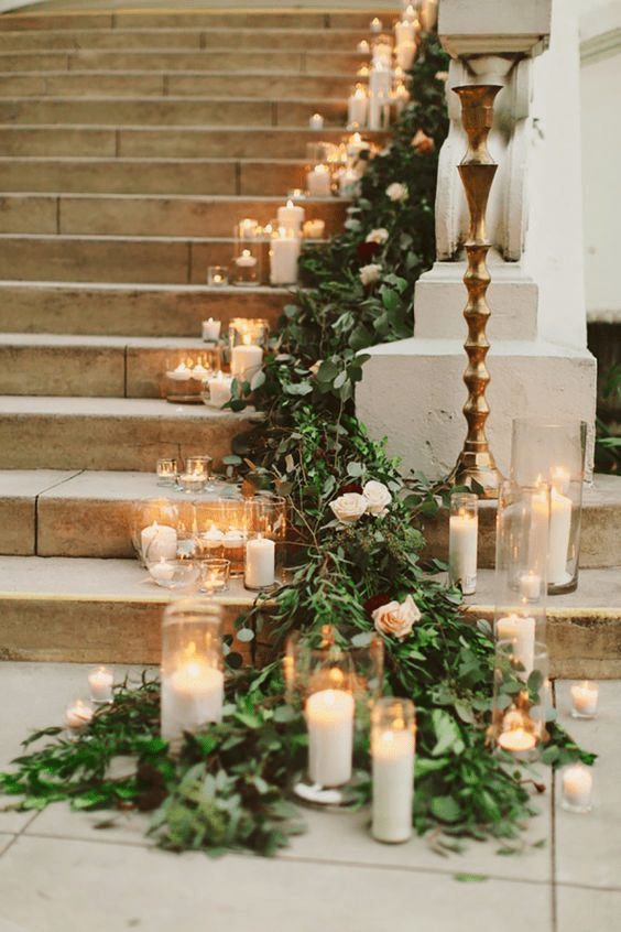 Romantic Staircase Aisle Draped in Greenery and Candles Romantic Staircase Aisle Draped in Greenery and Candles — Christmas Wedding Decor