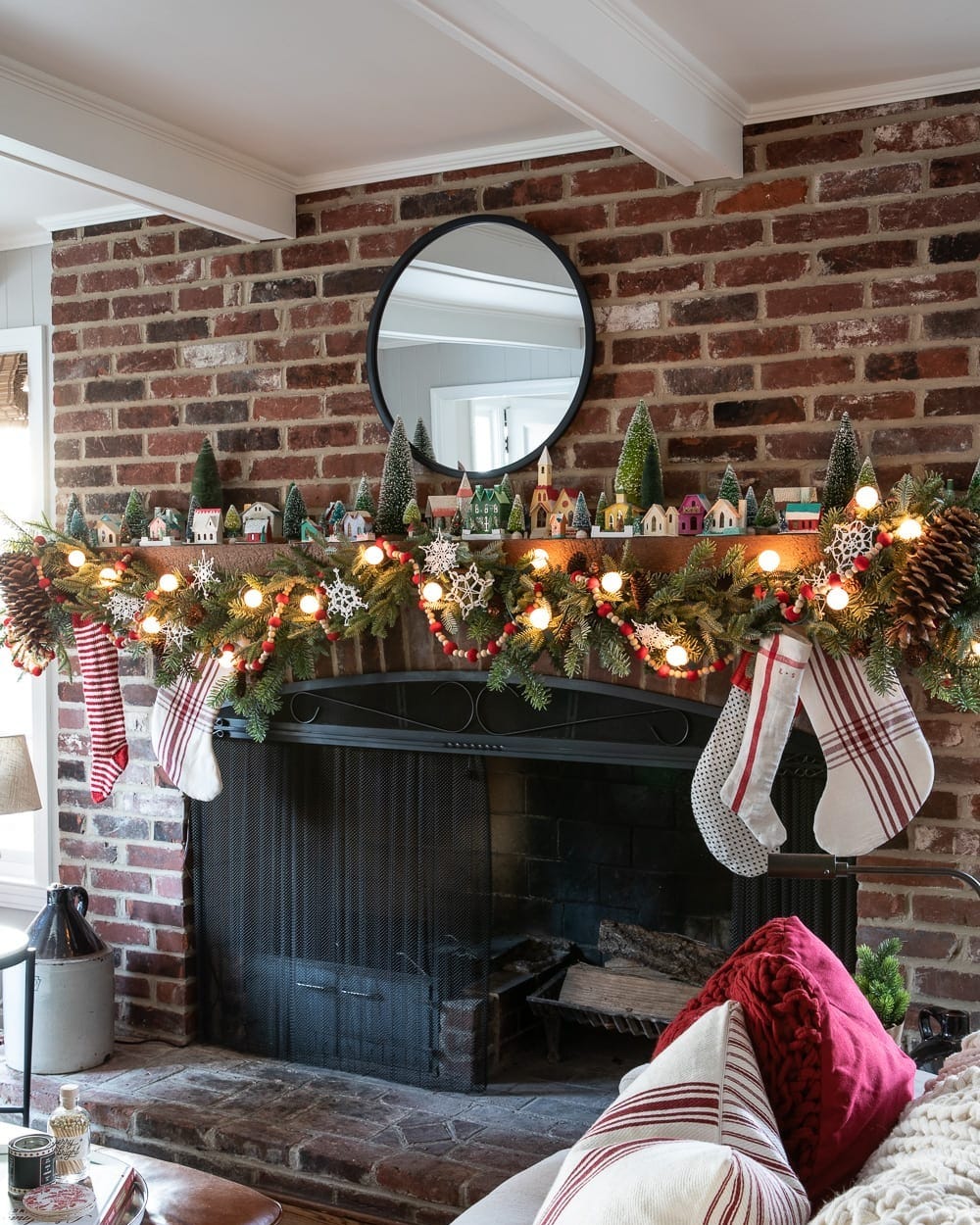 Traditional Brick Mantel with Miniature Village and Striped Stockings — Christmas Mantel Decor