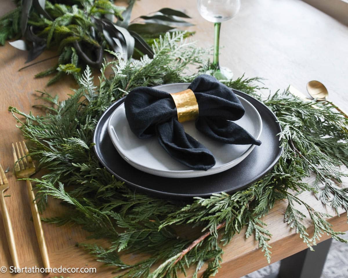 Dark Plates and Cedar Garland for a Modern Rustic Christmas Setting Dark Plates and Cedar Garland for a Modern Rustic Christmas Setting — Elegant Christmas Table Setting