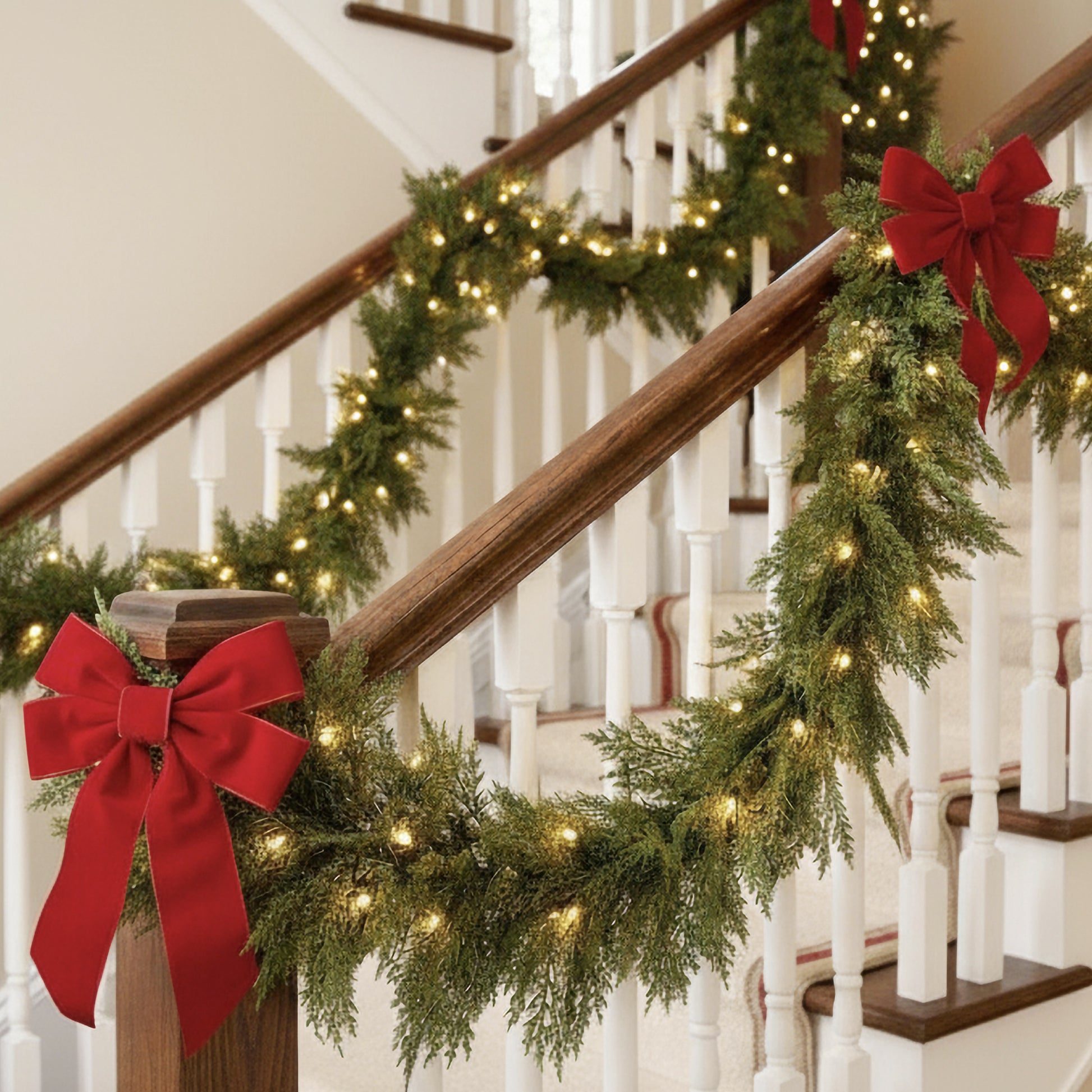 Pre-Lit Garland with Bright Red Velvet Bows on a Staircase Pre-Lit Garland with Bright Red Velvet Bows on a Staircase — Christmas Garland