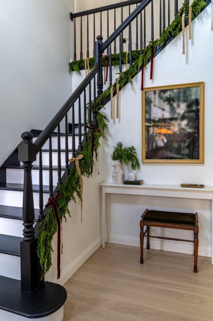 Modern Black Staircase with Simple Evergreen Garland and Red/Gold Ribbons Modern Black Staircase with Simple Evergreen Garland and Red/Gold Ribbons — Christmas Staircase Decor