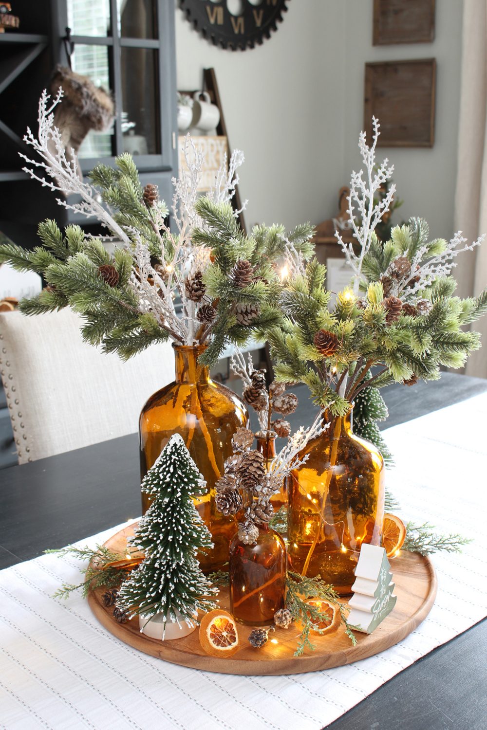 Eclectic Amber Bottles with Greenery and Fairy Lights — Christmas Centerpiece