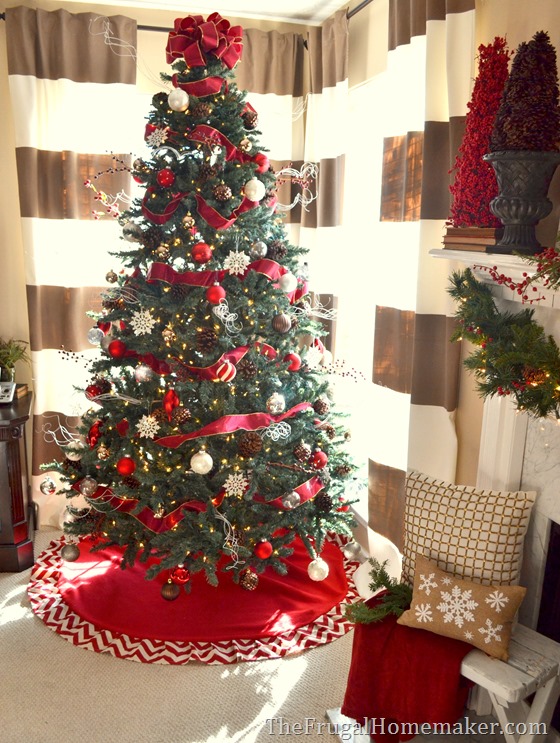 Traditional Christmas Tree Centered on a Red Tree Skirt with Snowflake Accents Traditional Christmas Tree Centered on a Red Tree Skirt with Snowflake Accents — Red and White Christmas Tree