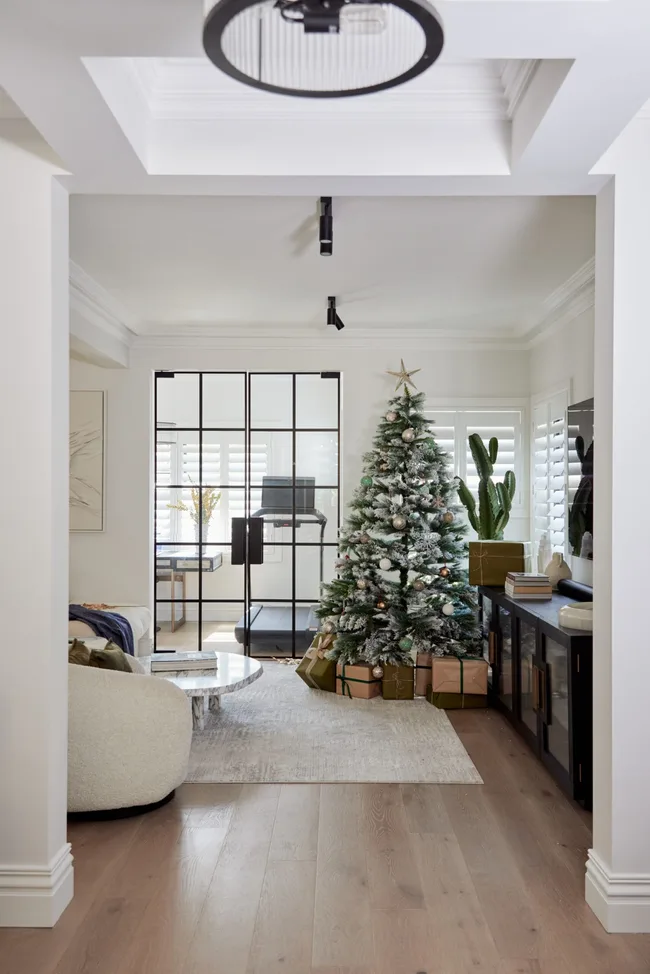 Elegant Modern Living Room with Flocked Christmas Tree and Glass Coffee Table — Modern Christmas Decor