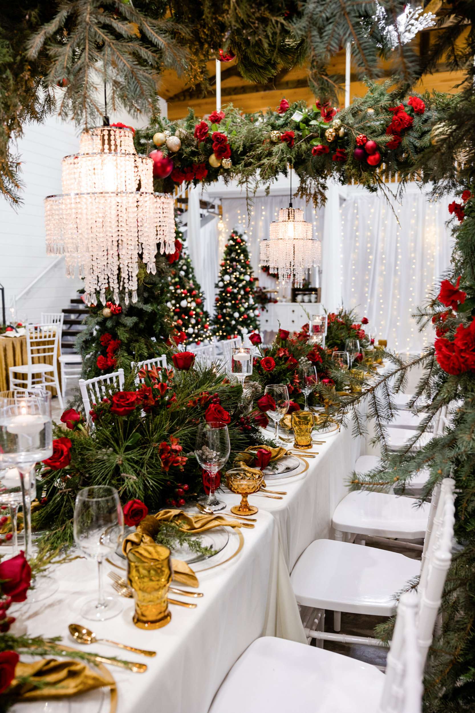 Glamorous Banquet Table with Red Roses and Evergreen Boughs Glamorous Banquet Table with Red Roses and Evergreen Boughs — Christmas Wedding Decor