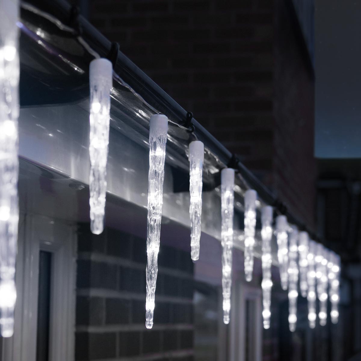 Close-Up of White LED Icicle Lights on Dark Eaves — Icicle Christmas Lights