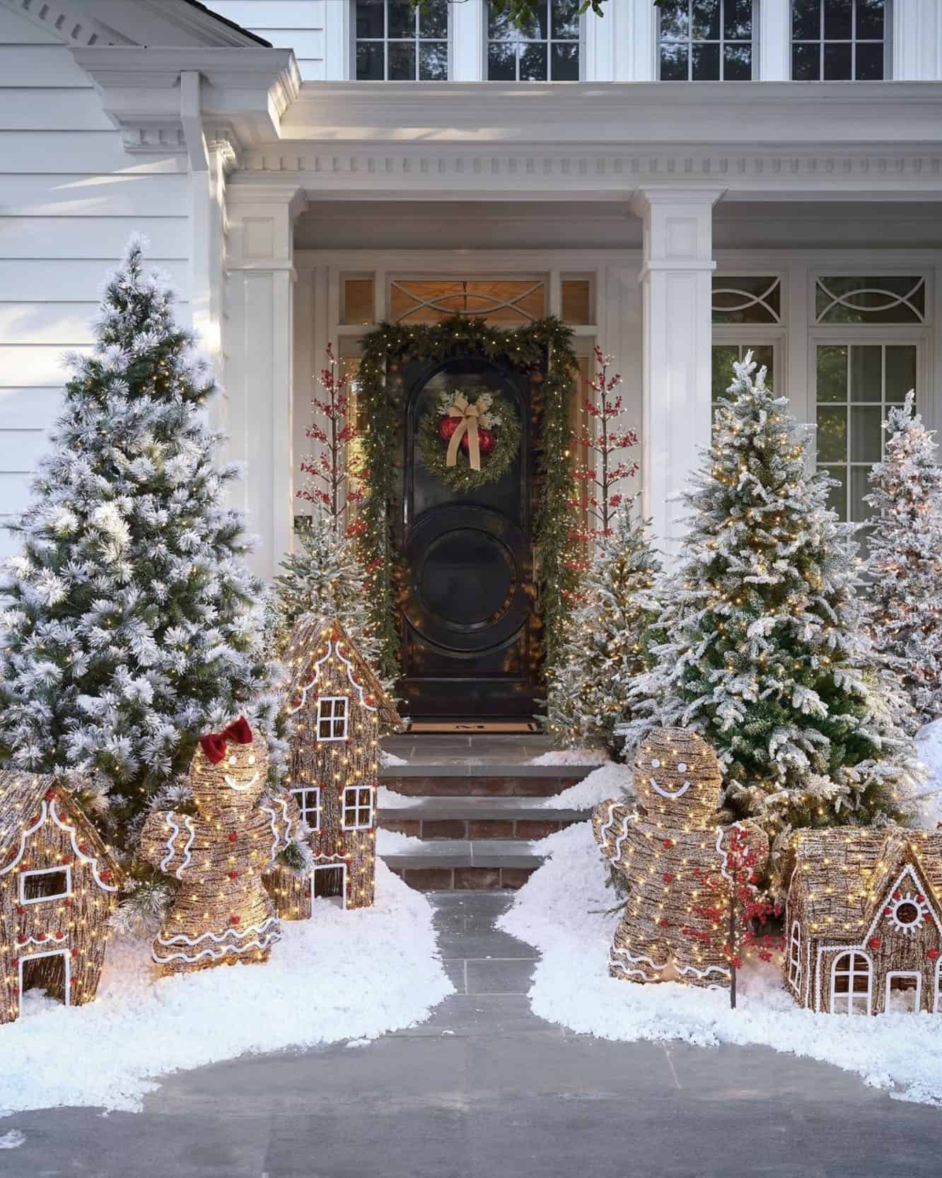Whimsical Porch with Illuminated Gingerbread Houses and Flocked Trees — Christmas House Exterior Decor