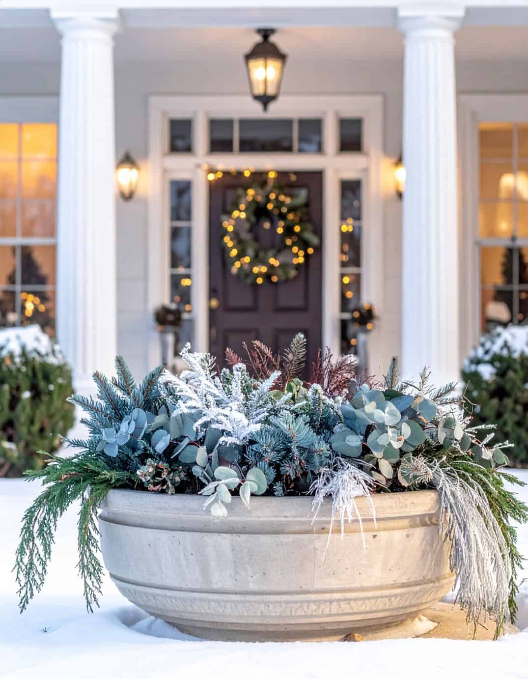 Natural Wintry Greenery in a Weathered Stone Planter Natural Wintry Greenery in a Weathered Stone Planter — Christmas Porch Planters