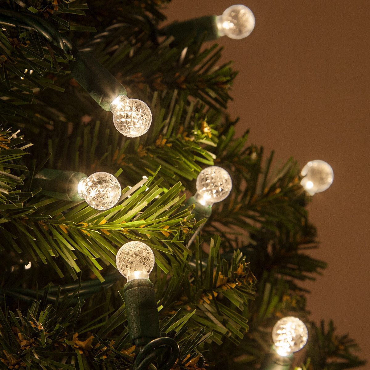 Clear Globe LED Lights Accentuate Green Christmas Tree Branches Clear Globe LED Lights Accentuate Green Christmas Tree Branches — Christmas Tree Lights
