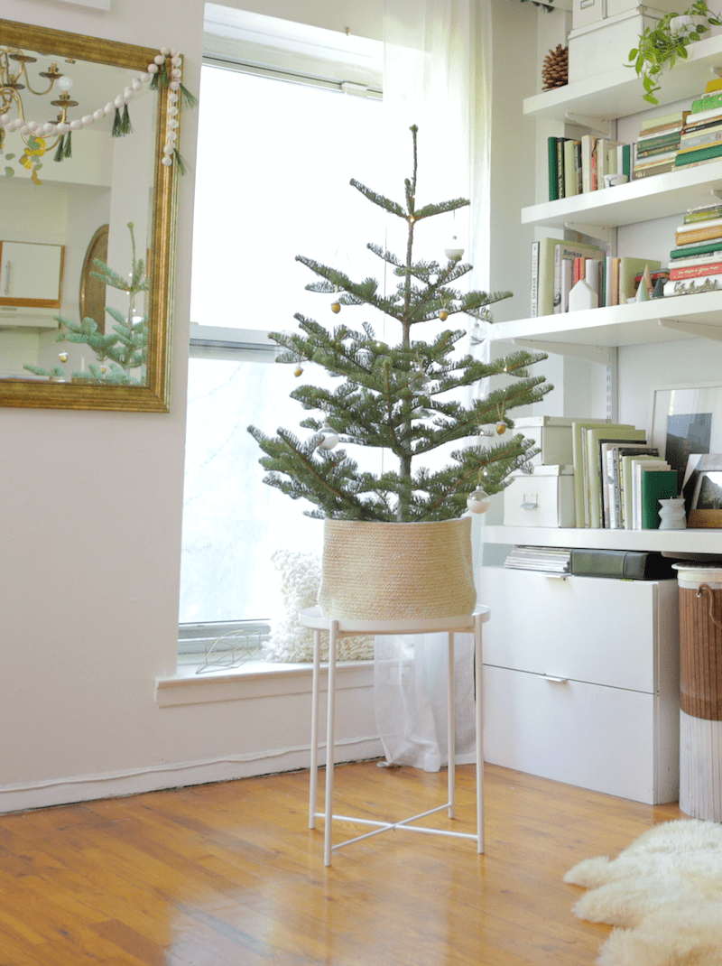 Small Tree in Jute Basket on White Side Table — Minimalist Christmas Tree
