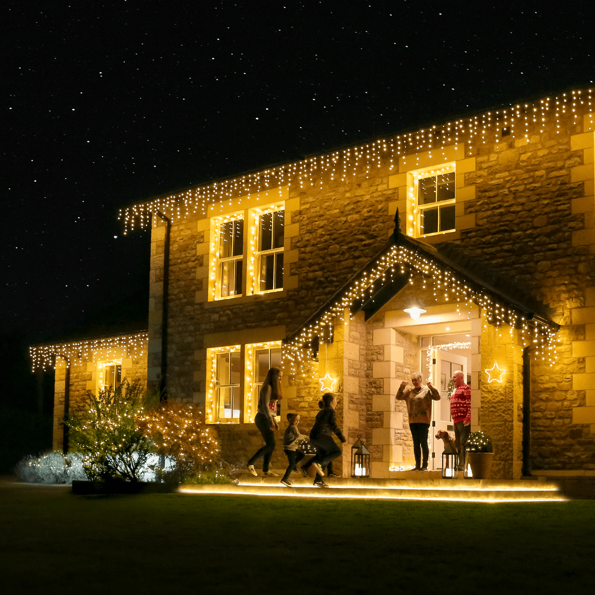 Cascading Warm White Icicle Lights on Stone House — Icicle Christmas Lights