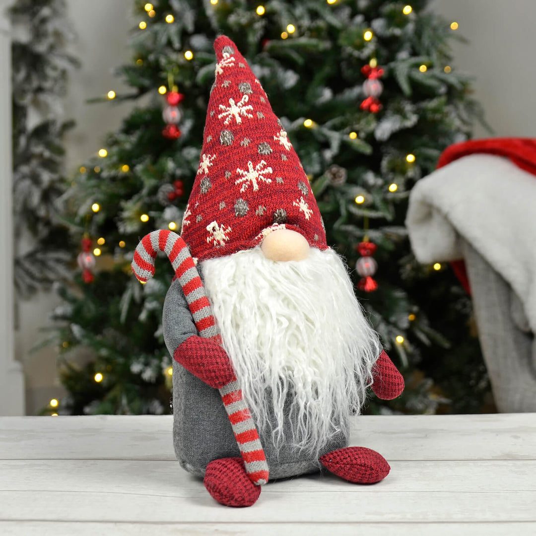 Festive Gnome Holding a Candy Cane Near a Christmas Tree — Candy Cane Christmas Decor