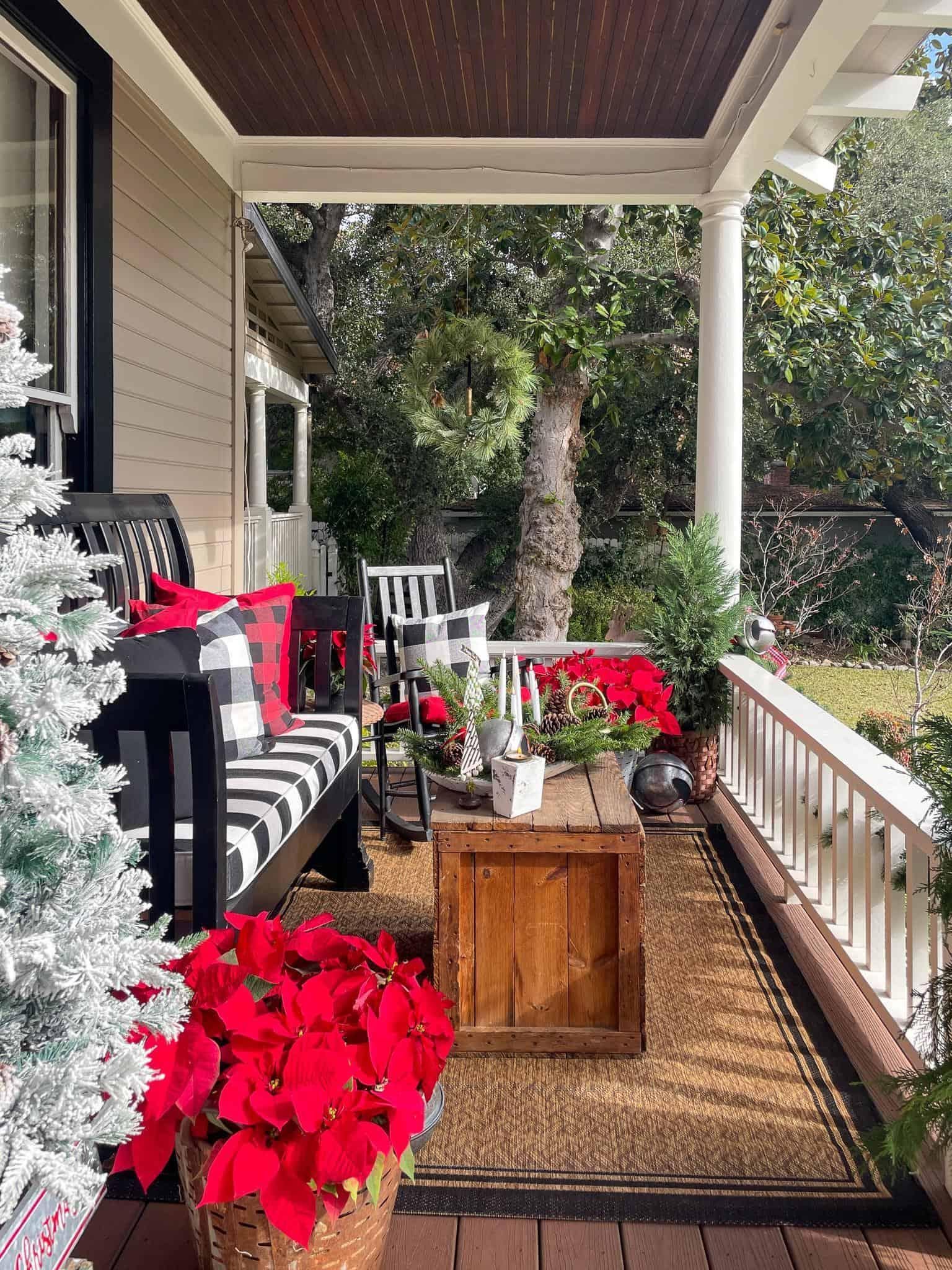 Cozy Farmhouse Porch Seating with Plaid Cushions and Poinsettias — Christmas Porch Decor