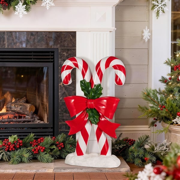 Candy Cane Pair by the Fireplace with a Red Bow — Candy Cane Christmas Decor