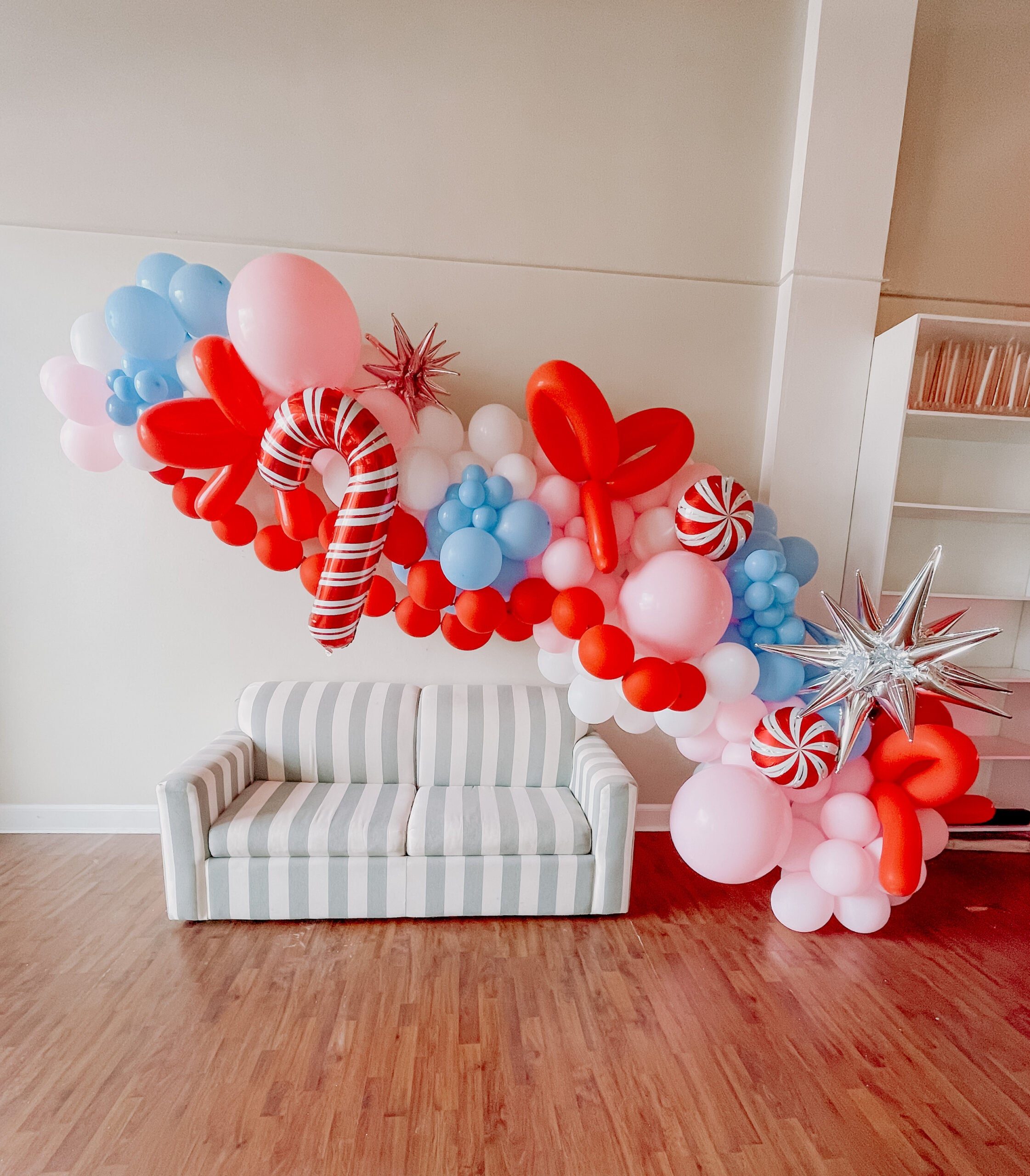 Modern Festive Balloon Garland Above a Striped Sofa — Christmas Balloon Garland