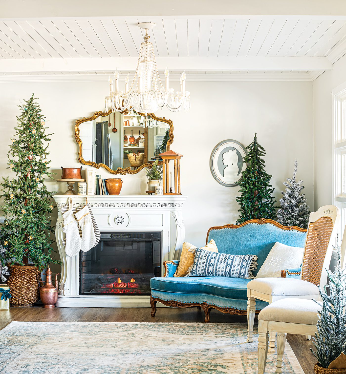 Symmetrical Fireplace with Flanking Trees and Blue Velvet Sofa — Rustic Christmas Decor