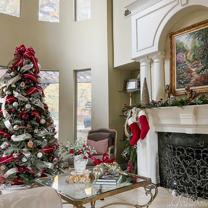 Tree And Fireplace As Focal Points Spacious Living Room with Red and White Ribbon Christmas Tree Tree And Fireplace As Focal Points Spacious Living Room with Red and White Ribbon Christmas Tree — Traditional Christmas Deco