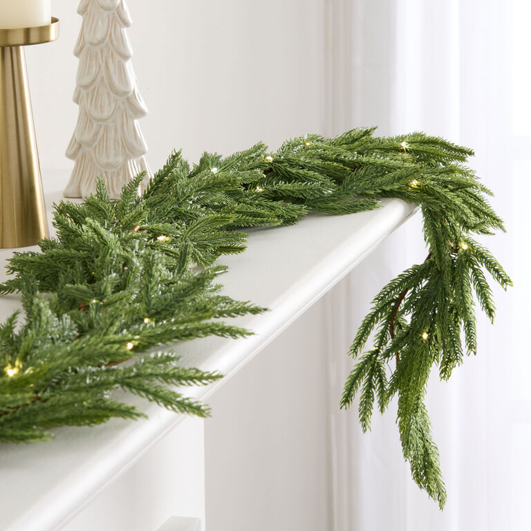Faux Pine Garland with Integrated LED Lights on a White Mantel Faux Pine Garland with Integrated LED Lights on a White Mantel — Christmas Garland
