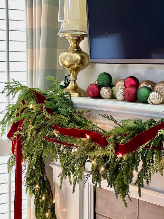 Greenery Garland with Burgundy Ribbon on a Christmas Mantel Greenery Garland with Burgundy Ribbon on a Christmas Mantel — Burgundy Christmas Decor