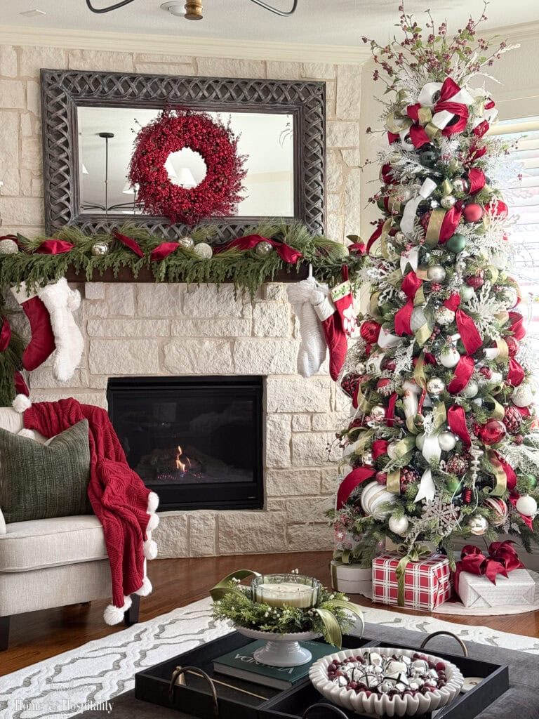 Traditional Christmas Tree with Red and Green Ornaments by Stone Fireplace — Christmas Tree Decorating