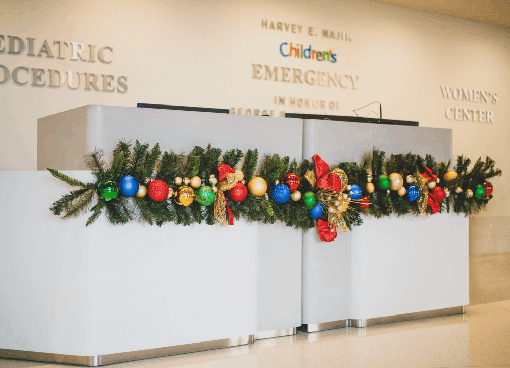 Vibrant Christmas Garland on Reception Desk Vibrant Christmas Garland on Reception Desk — Christmas Office Decor Ideas