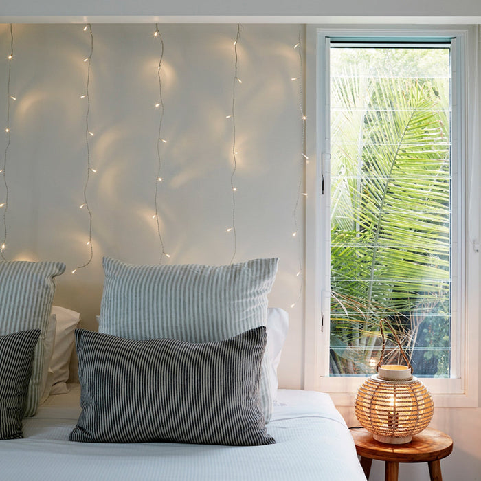 Boho Bedroom with Striped Bedding and Fairy Lights Behind Pillows — Christmas Fairy Lights Headboard