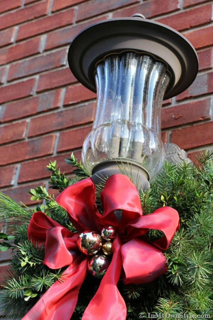 Outdoor Lantern Fixture Decorated with Pine Garland and Red Bow — Christmas Porch Lanterns