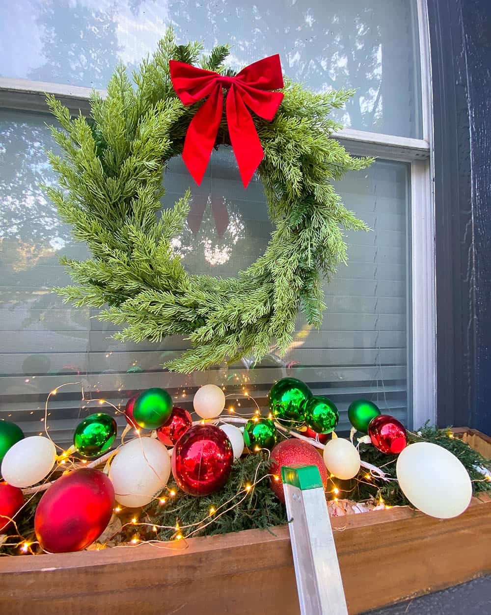 Large Evergreen Wreath with Bold Red Bow on a Porch Window — Christmas Window Wreaths