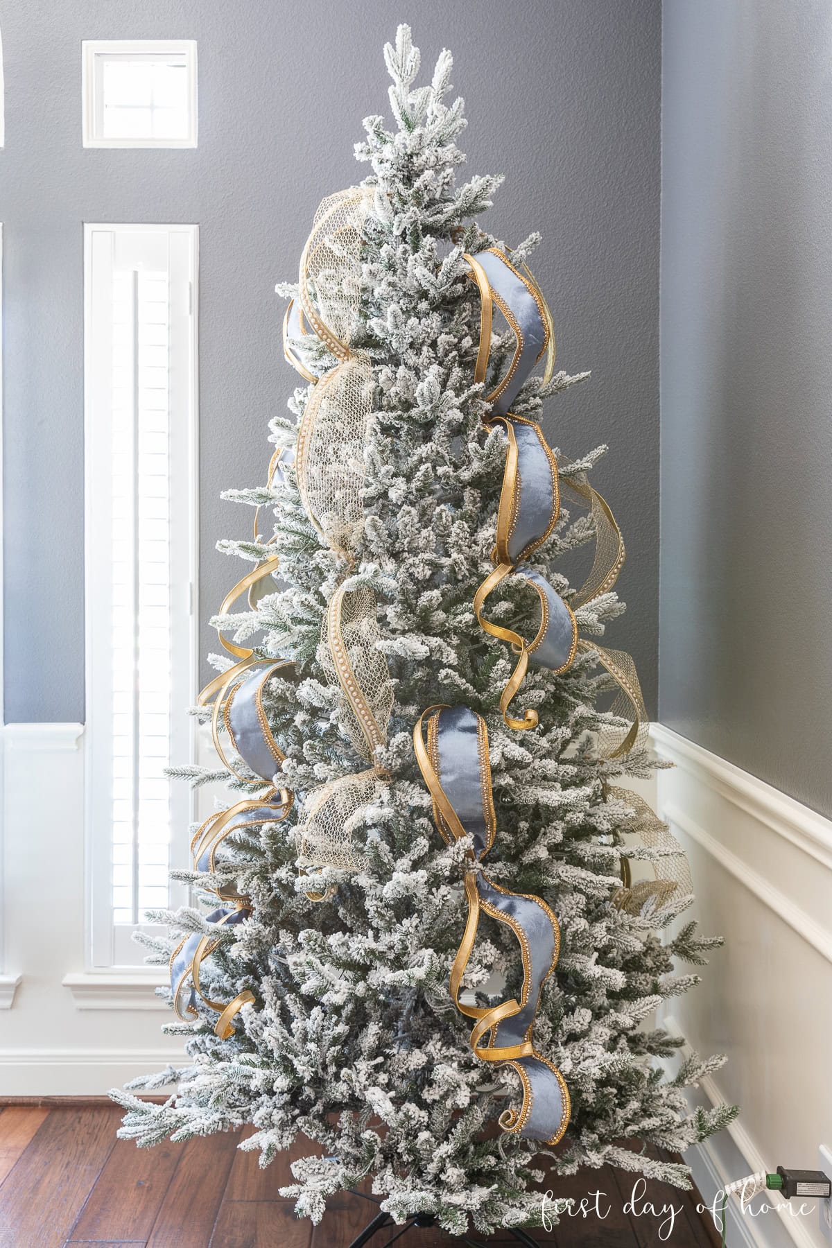 Flocked Christmas tree adorned with gold and grey ribbons Flocked Christmas tree adorned with gold and grey ribbons — Gold and White Christmas Tree
