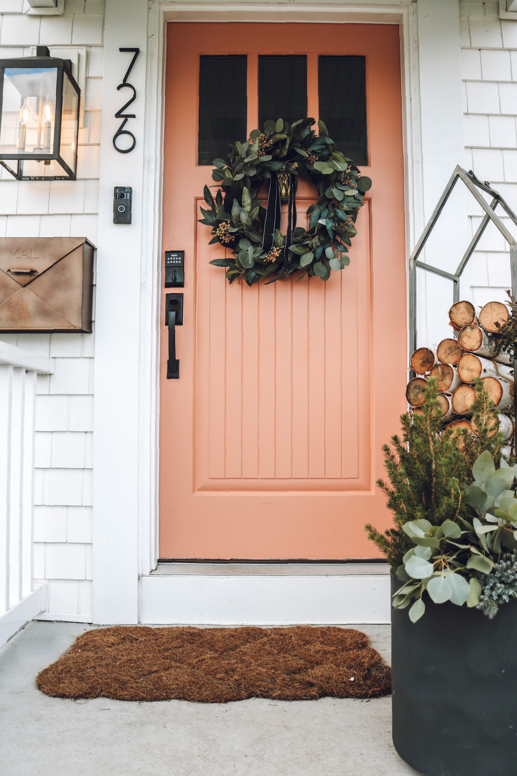 Inviting Farmhouse Porch with Wicker Chair and Lanterns Inviting Farmhouse Porch with Wicker Chair and Lanterns — Winter Front Door Decor