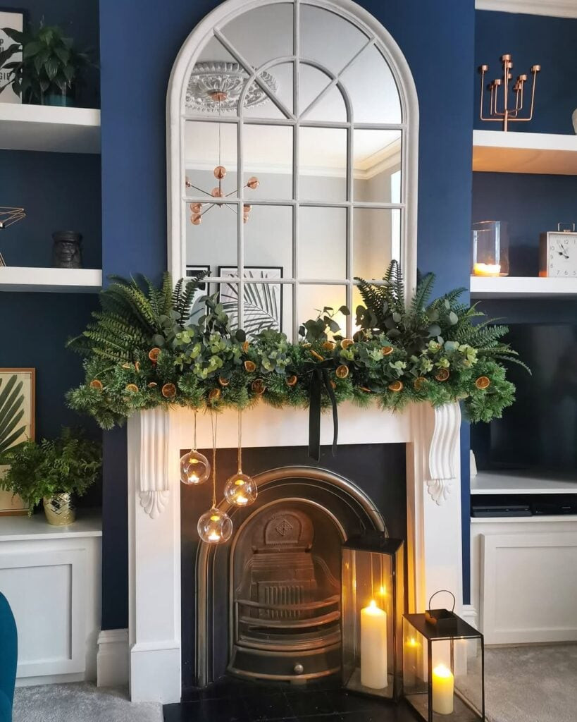 Dramatic Greenery Cascade with Dried Oranges on a Deep Blue Mantel — Winter Mantel Decor