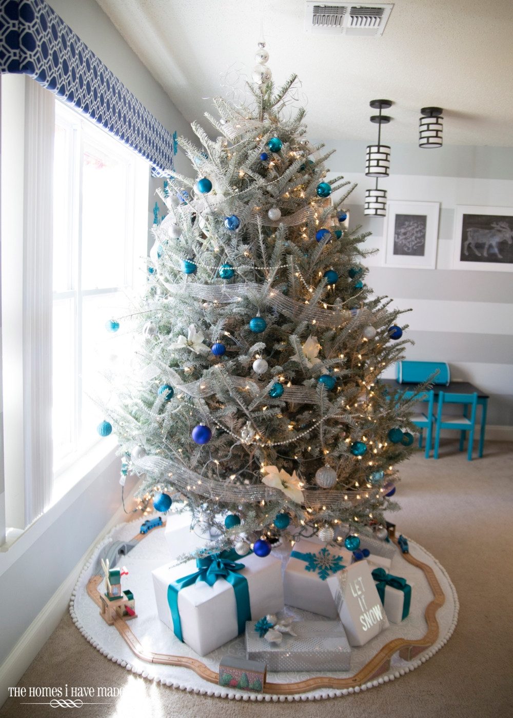 Flocked Tree with Blue/Silver Ornaments and Toy Train Accent Flocked Tree with Blue/Silver Ornaments and Toy Train Accent — Blue and Silver Christmas Tree