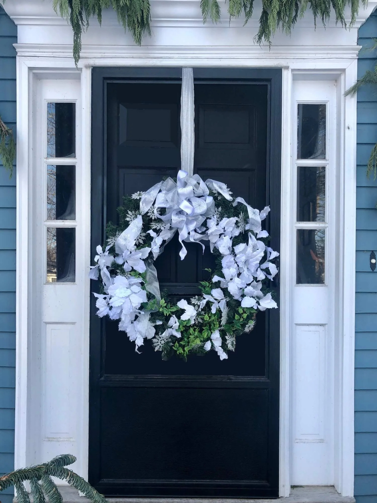 Sophisticated Black Door with White Floral Winter Wreath Sophisticated Black Door with White Floral Winter Wreath — Winter Front Door Decor