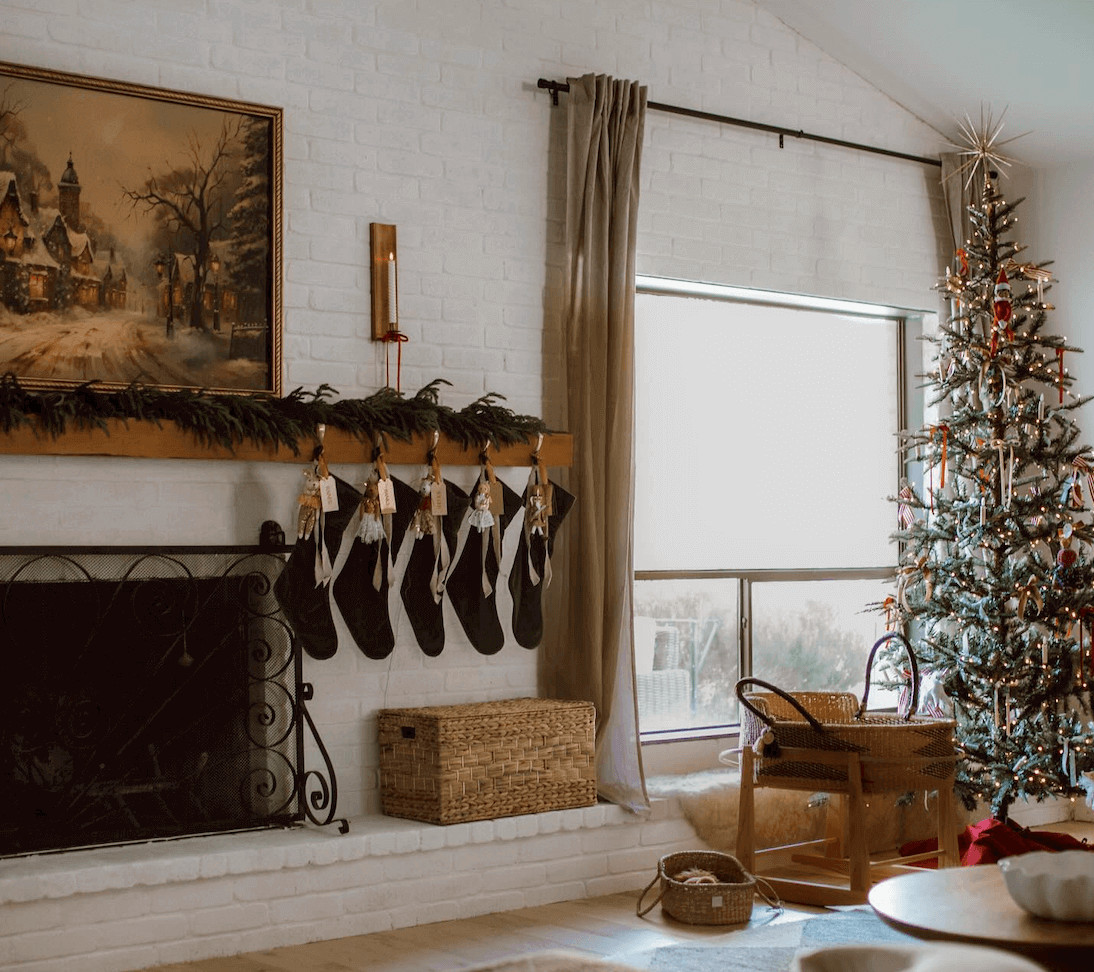 Striking Black Stockings on a White Brick Mantel with Garland — Winter Mantel Decor