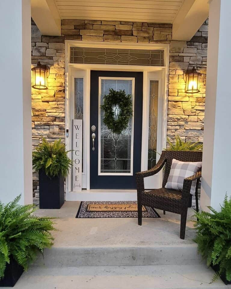 Stone Facade Porch with Symmetrical Lanterns and Wicker Chair Stone Facade Porch with Symmetrical Lanterns and Wicker Chair — Winter Front Door Decor