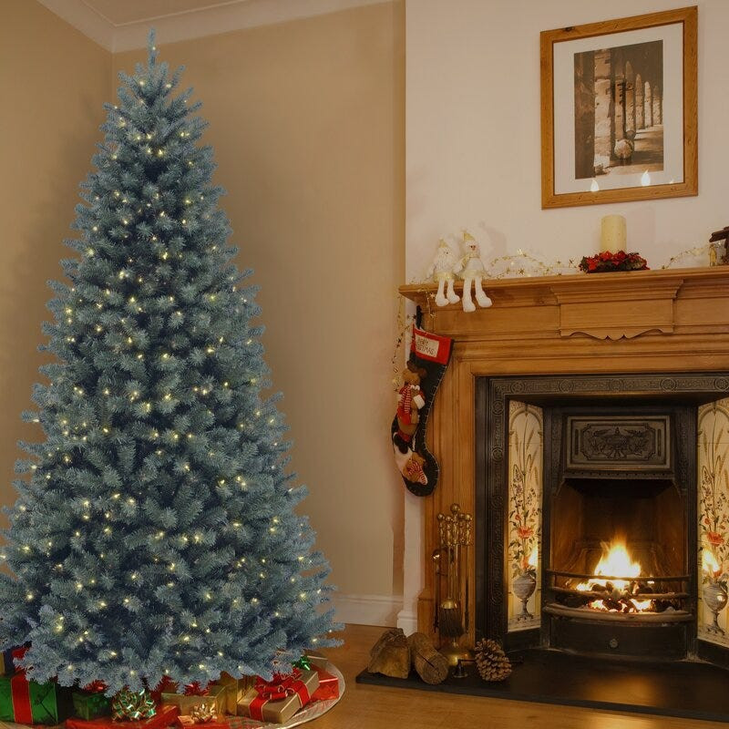 Blue-Toned Artificial Tree Beside a Traditional Fireplace Blue-Toned Artificial Tree Beside a Traditional Fireplace — Blue and Silver Christmas Tree